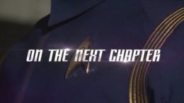 Close up shot of a brand new delta insignia and a blue Starfleet uniform with gold accents.